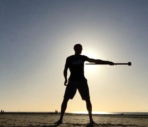 Johan Swennen met een macebell op het strand